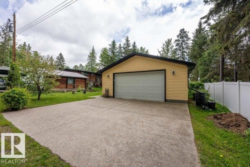 Detached garage with horizontal siding, a paneled overhead door, and an exterior light fixture - 90 2001 Twp Rd, Rural Leduc County, AB 