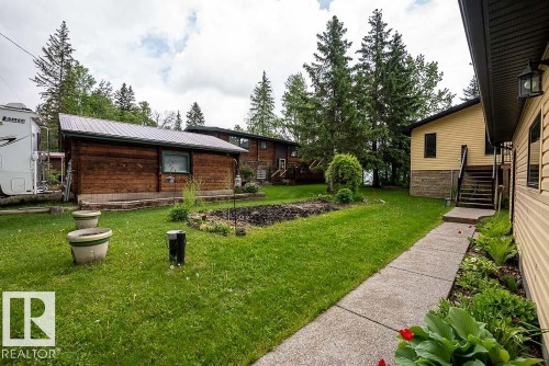 Expansive green lawn with a concrete pathway leading to a raised entry - 90 2001 Twp Rd, Rural Leduc County, AB 