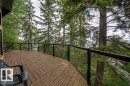 Expansive wood-finish deck with glass panel railing - 90 2001 Twp Rd, Rural Leduc County, AB 