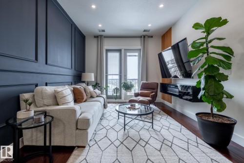 The living area features hardwood floors and recessed lighting - 454 6079 Maynard Way, Edmonton, AB - Indoor Photo Showing Other Room