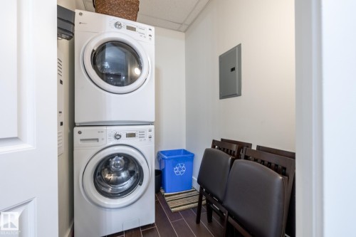 Laundry area featuring a stackable washer and dryer, and dark tile flooring - 454 6079 Maynard Way, Edmonton, AB - Indoor Photo Showing Laundry Room