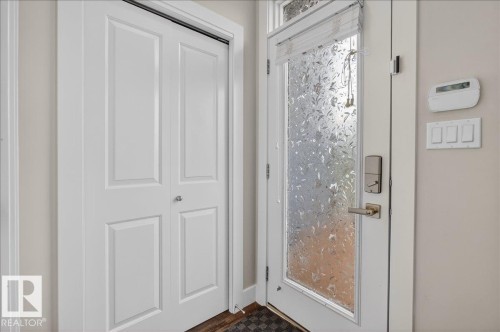 Entryway featuring a white paneled door with a polished knob, and a front door with a decorative frosted glass insert - 9034 Rosenthal Link Link, Edmonton, AB - Indoor Photo Showing Other Room