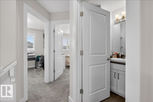 View of a hallway featuring neutral-toned walls, white trim, and a textured ceiling - 9034 Rosenthal Link Link, Edmonton, AB - Indoor Photo Showing Other Room