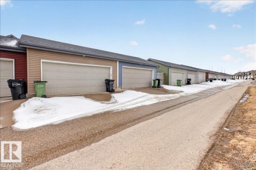 Attached garage with light-colored siding and a matching garage door - 9034 Rosenthal Link Link, Edmonton, AB - Outdoor