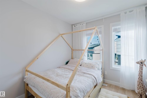 This room features light-colored walls and flooring, with two windows providing natural light - 1129 Keswick Drive, Edmonton, AB - Indoor Photo Showing Bedroom