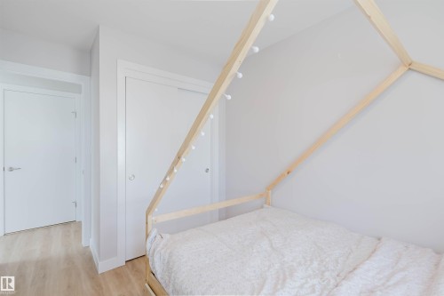 The room features light-colored walls and light wood-style flooring, creating a bright and airy atmosphere - 1129 Keswick Drive, Edmonton, AB - Indoor Photo Showing Bedroom