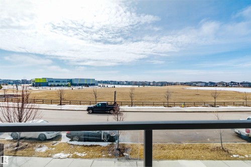 Enjoy extensive views of the surrounding area, featuring a large field, a modern building with bright green and yellow accents, and distant residential properties - 1129 Keswick Drive, Edmonton, AB - Outdoor With View