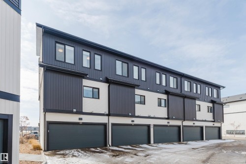 This property features a contemporary exterior design with contrasting dark gray and white siding - 1129 Keswick Drive, Edmonton, AB - Outdoor With Exterior