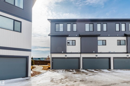 The property features a contemporary exterior design with contrasting dark gray and white siding - 1129 Keswick Drive, Edmonton, AB - Outdoor With Exterior