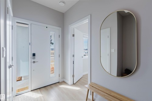 The property features a bright entryway with light-colored flooring, a white front door with a glass panel, and a smart lock - 1129 Keswick Drive, Edmonton, AB - Indoor Photo Showing Other Room