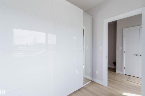 This interior space features light-colored flooring and white walls, creating a bright and airy feel - 1129 Keswick Drive, Edmonton, AB - Indoor Photo Showing Other Room