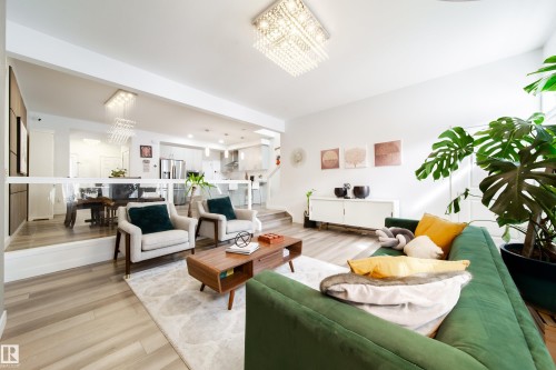 The bright living area showcases light-toned flooring, a statement chandelier, and a decorative rug - 22931 96 Avenue, Edmonton, AB - Indoor Photo Showing Living Room