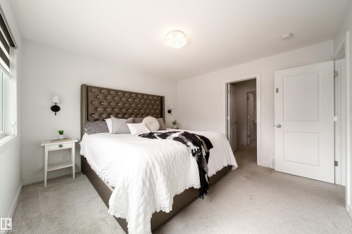 Well-appointed room featuring light-colored carpeting, a window providing natural light, and a white interior door - 22931 96 Avenue, Edmonton, AB - Indoor Photo Showing Bedroom