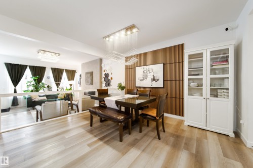 The property features light-toned wood flooring throughout the dining area, which is illuminated by a contemporary chandelier - 22931 96 Avenue, Edmonton, AB - Indoor Photo Showing Dining Room