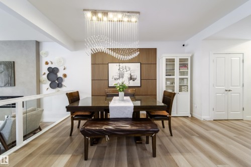 Dining area featuring light wood flooring, a contemporary chandelier, and a decorative slatted wood accent wall - 22931 96 Avenue, Edmonton, AB - Indoor Photo Showing Dining Room