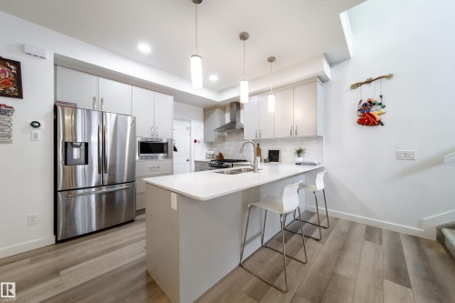The kitchen features stainless steel appliances, light-toned cabinetry, and a central island with a white countertop - 22931 96 Avenue, Edmonton, AB - Indoor Photo Showing Kitchen With Double Sink With Upgraded Kitchen