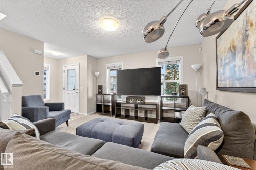 The living room features neutral wall colors, recessed ceiling lighting, and multiple windows providing natural light - 219 60 Street, Edmonton, AB - Indoor Photo Showing Living Room