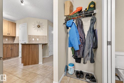 The property features a kitchen with wood cabinetry, a tiled backsplash, and tiled flooring - 219 60 Street, Edmonton, AB - Indoor Photo Showing Other Room