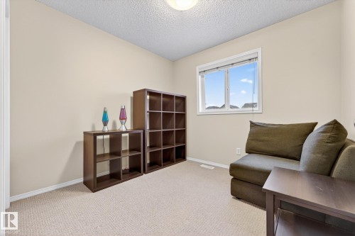 This room features light-colored walls and carpeting, a window providing natural light, and a ceiling light fixture - 219 60 Street, Edmonton, AB - Indoor
