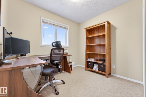 This room offers a versatile space with carpeting, light-colored walls, and a window providing natural light - 219 60 Street, Edmonton, AB - Indoor Photo Showing Office