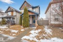This property features a welcoming facade with a covered porch, a dark blue entry door, and cedar shake accents - 219 60 Street, Edmonton, AB  - Outdoor With Facade 