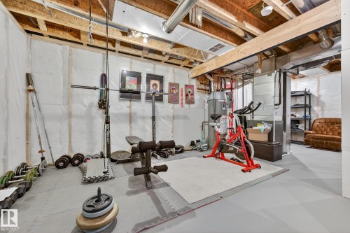 The unfinished basement features exposed wooden ceiling joists and an open layout, providing adaptable space - 219 60 Street, Edmonton, AB - Indoor