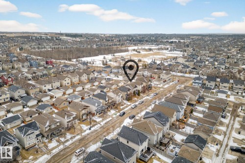 Aerial view of the property and surrounding neighborhood, featuring residential streets, houses with various roof styles, and open land areas - 219 60 Street, Edmonton, AB - Outdoor With View