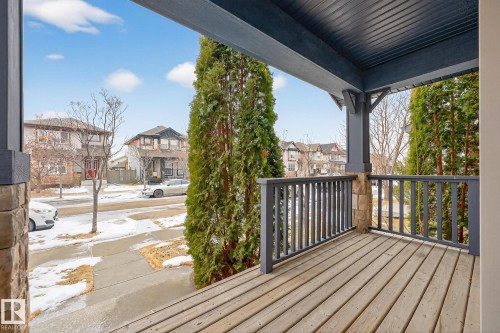The property features a wooden deck with a dark grey railing and stone-clad pillars, providing an inviting outdoor space - 219 60 Street, Edmonton, AB - Outdoor With Deck Patio Veranda With Exterior