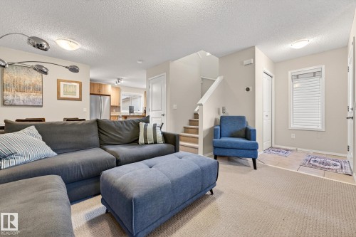 The property features a bright living area with light-colored walls and a textured ceiling - 219 60 Street, Edmonton, AB - Indoor Photo Showing Living Room
