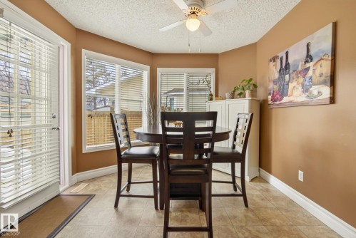 This dining area features neutral-toned walls and tiled flooring - 12815 156 Avenue, Edmonton, AB - Indoor Photo Showing Dining Room