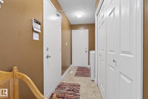 Entryway featuring light brown walls, white doors, and tiled flooring - 12815 156 Avenue, Edmonton, AB - Indoor Photo Showing Other Room