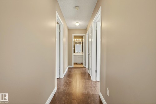 Hallway with light brown walls and wood flooring - 12815 156 Avenue, Edmonton, AB - Indoor Photo Showing Other Room