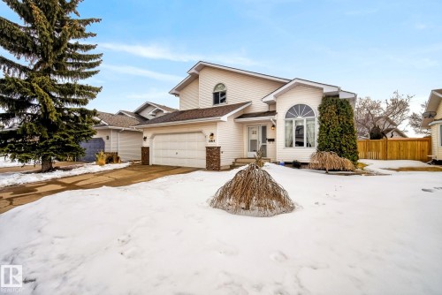 The property features a white exterior, an attached garage, and a driveway - 12815 156 Avenue, Edmonton, AB - Outdoor With Facade