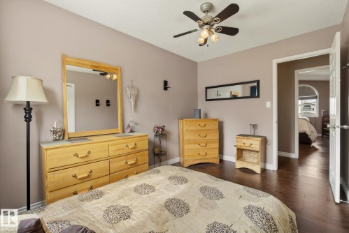 This inviting bedroom features rich dark wood flooring and a ceiling fan with integrated lighting - 12815 156 Avenue, Edmonton, AB - Indoor Photo Showing Bedroom