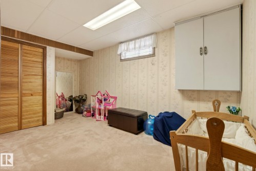 Room with carpeted floors, louvered closet doors, and wall-mounted cabinetry - 12815 156 Avenue, Edmonton, AB - Indoor