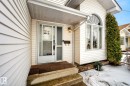 The property features white siding, a front entry with a storm door, and an arched window - 12815 156 Avenue, Edmonton, AB  - Outdoor With Exterior 