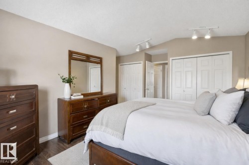Bedroom featuring track lighting, light-colored walls, and dark hardwood floors - 12815 156 Avenue, Edmonton, AB - Indoor Photo Showing Bedroom