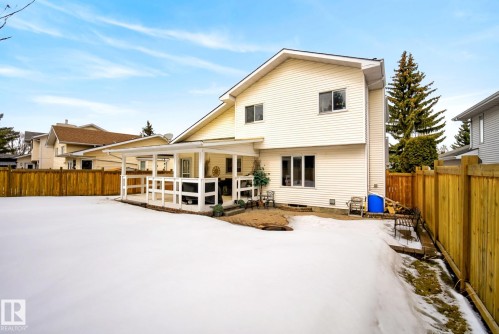The property features a spacious yard with a covered patio area and a wooden fence - 12815 156 Avenue, Edmonton, AB - Outdoor