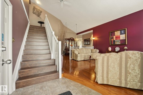 The property features a staircase with wooden treads and white balusters, leading to a higher level - 12815 156 Avenue, Edmonton, AB - Indoor Photo Showing Other Room