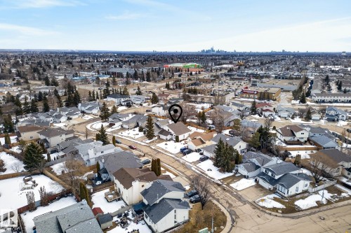 The property is situated within a residential neighborhood featuring detached homes and mature trees - 12815 156 Avenue, Edmonton, AB - Outdoor With View