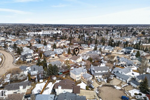 This aerial view highlights the property's location within a developed residential area, characterized by numerous houses with varied rooflines and surrounding trees - 12815 156 Avenue, Edmonton, AB - Outdoor With View