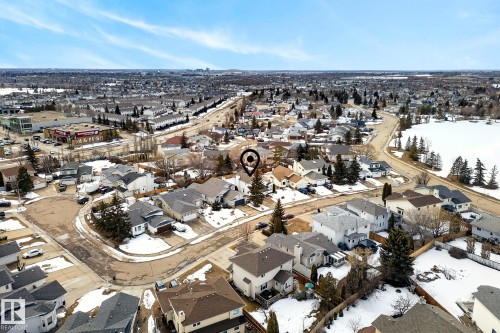 Aerial view of the property and surrounding neighborhood, featuring residential homes, a tree-lined street, and a nearby body of water - 12815 156 Avenue, Edmonton, AB - Outdoor With View