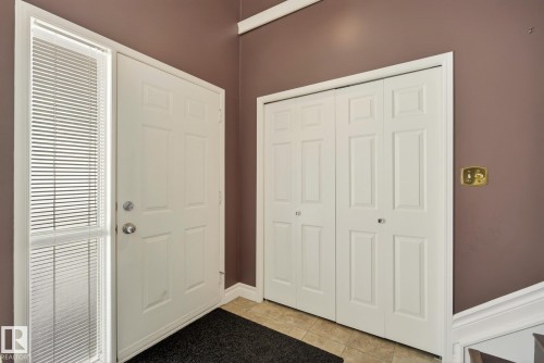 Entryway featuring a white paneled door with a sidelight, a bi-fold closet, and tiled flooring - 12815 156 Avenue, Edmonton, AB - Indoor Photo Showing Other Room