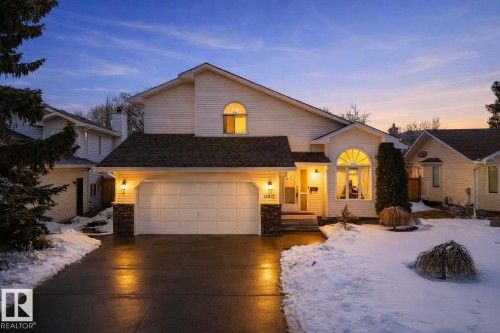 The property features a two-car garage, an arched window, and exterior wall lanterns - 12815 156 Avenue, Edmonton, AB - Outdoor