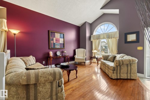 The living area features hardwood floors and vaulted ceilings - 12815 156 Avenue, Edmonton, AB - Indoor Photo Showing Living Room