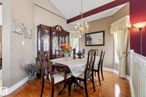 This dining area features hardwood floors and a chandelier - 12815 156 Avenue, Edmonton, AB - Indoor Photo Showing Dining Room