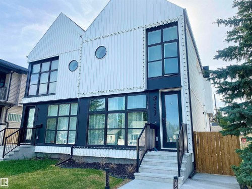 Modern duplex exterior featuring white vertical siding with dark trim accents - 10936 117 Street, Edmonton, AB - Outdoor