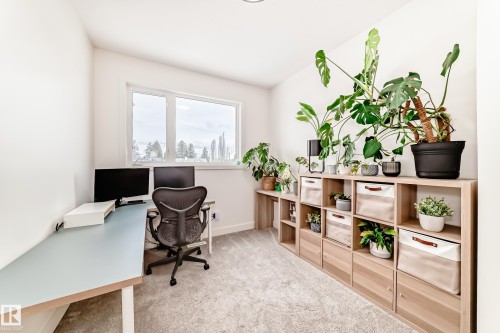 Versatile room featuring a light-colored desk area, a window providing natural light, and integrated shelving units with storage - 10936 117 Street, Edmonton, AB - Indoor Photo Showing Office