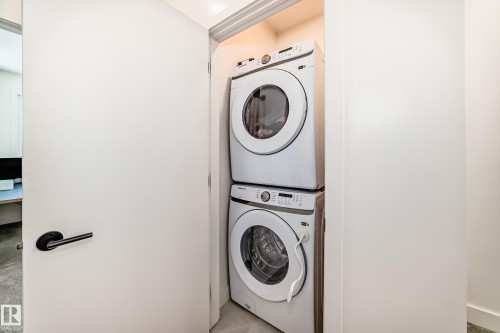 Laundry area featuring a stacked washer and dryer - 10936 117 Street, Edmonton, AB - Indoor Photo Showing Laundry Room
