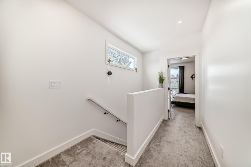 Carpeted hallway with white walls and a window providing natural light - 10936 117 Street, Edmonton, AB - Indoor Photo Showing Other Room